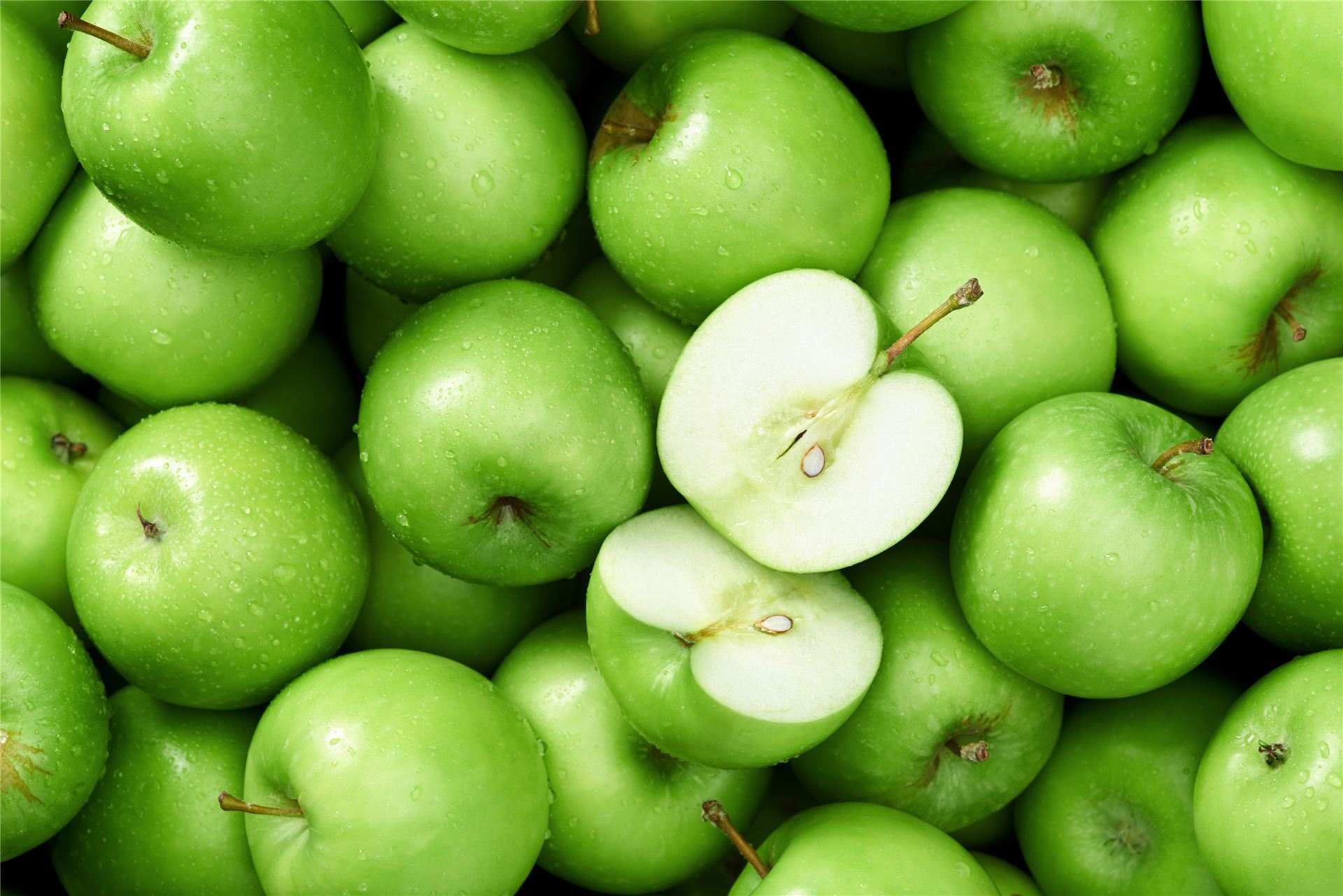 Granny Smith apples, one cut in half